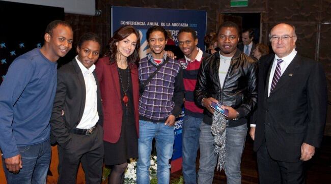 Lourdes Reyzabal, fundadora de la Fundación Raíces, acompañada por chicos a los que ha ayudado y Carlos Carnicer, presidente del Consejo General de la Abogacía española.