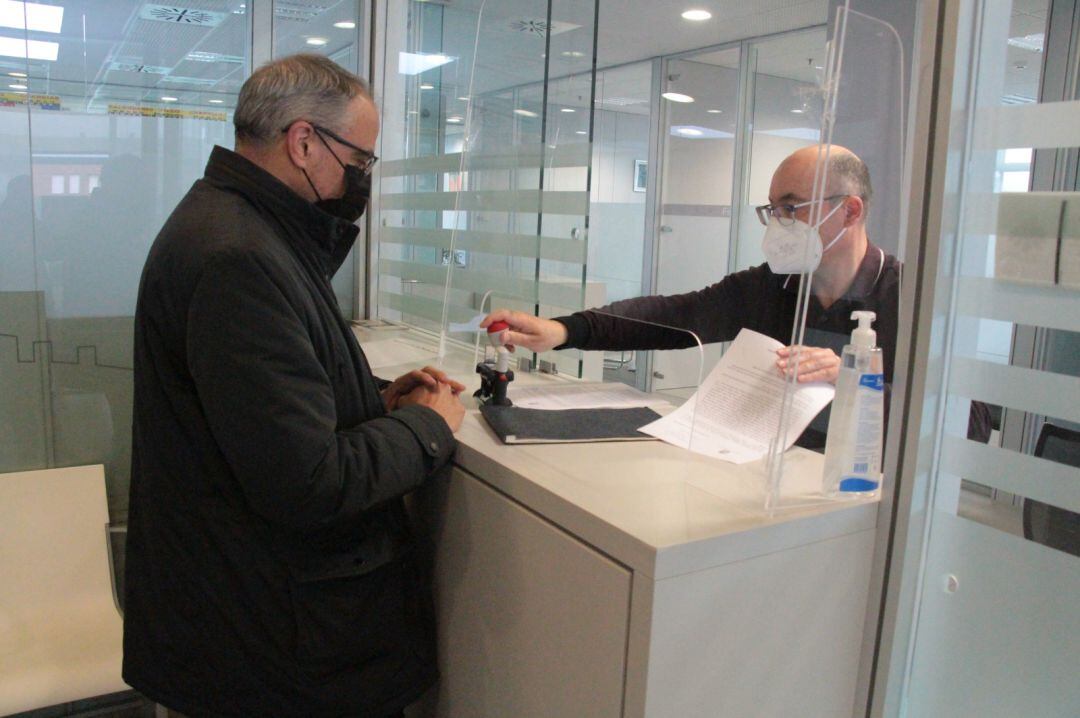 Olegario Ramón entrgando el cuaderno en la fiscalía