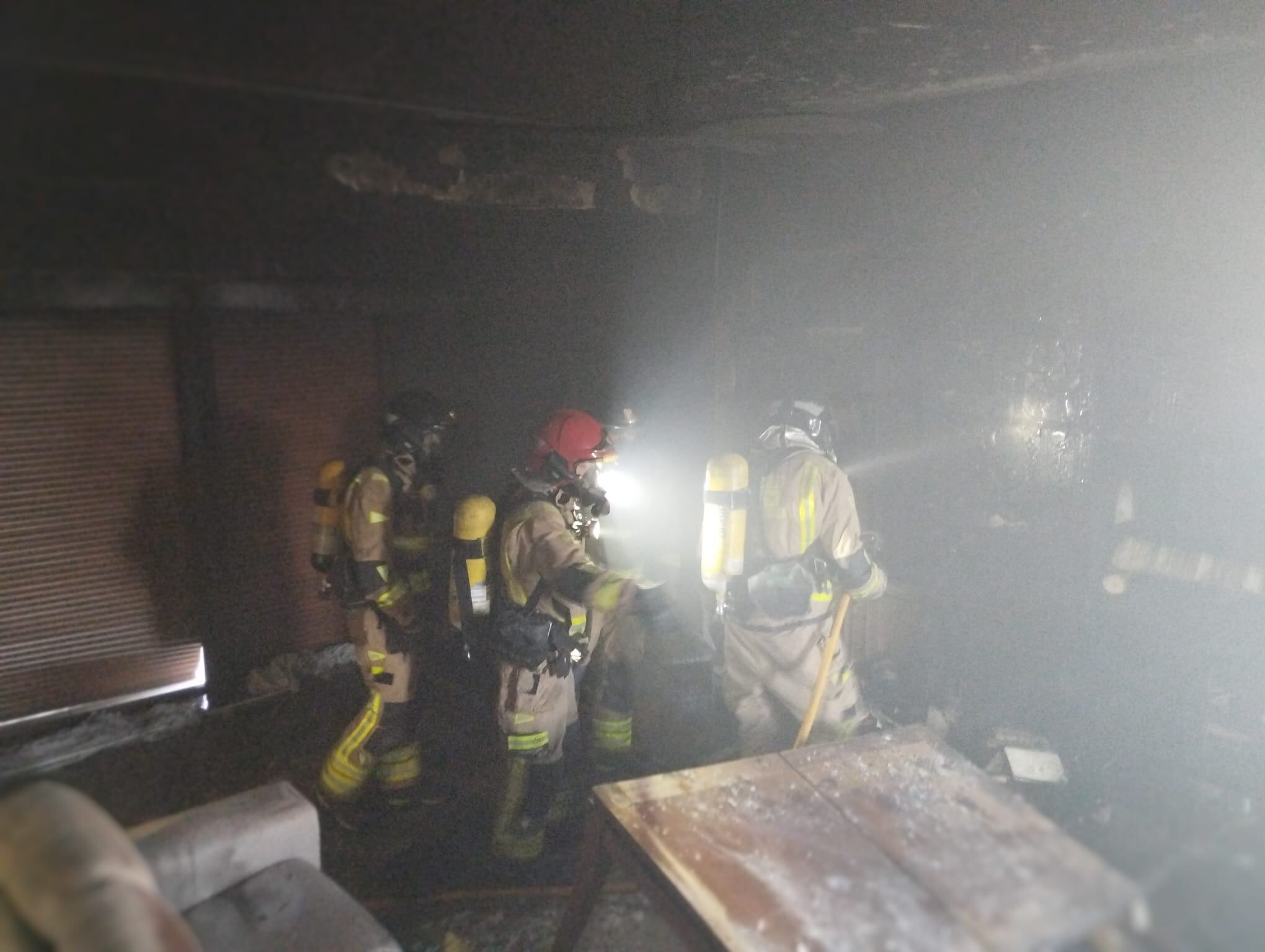 Bomberos en el interior de la vivienda incendiada en Las Torres de Cotillas