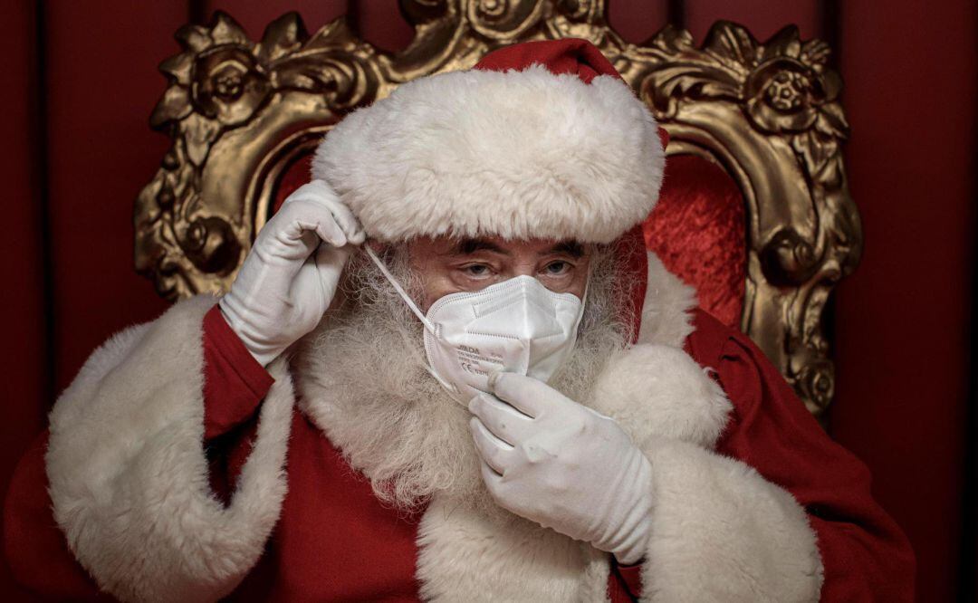 Una persona vestida de Papá Noel con mascarilla para evitar contagios 
