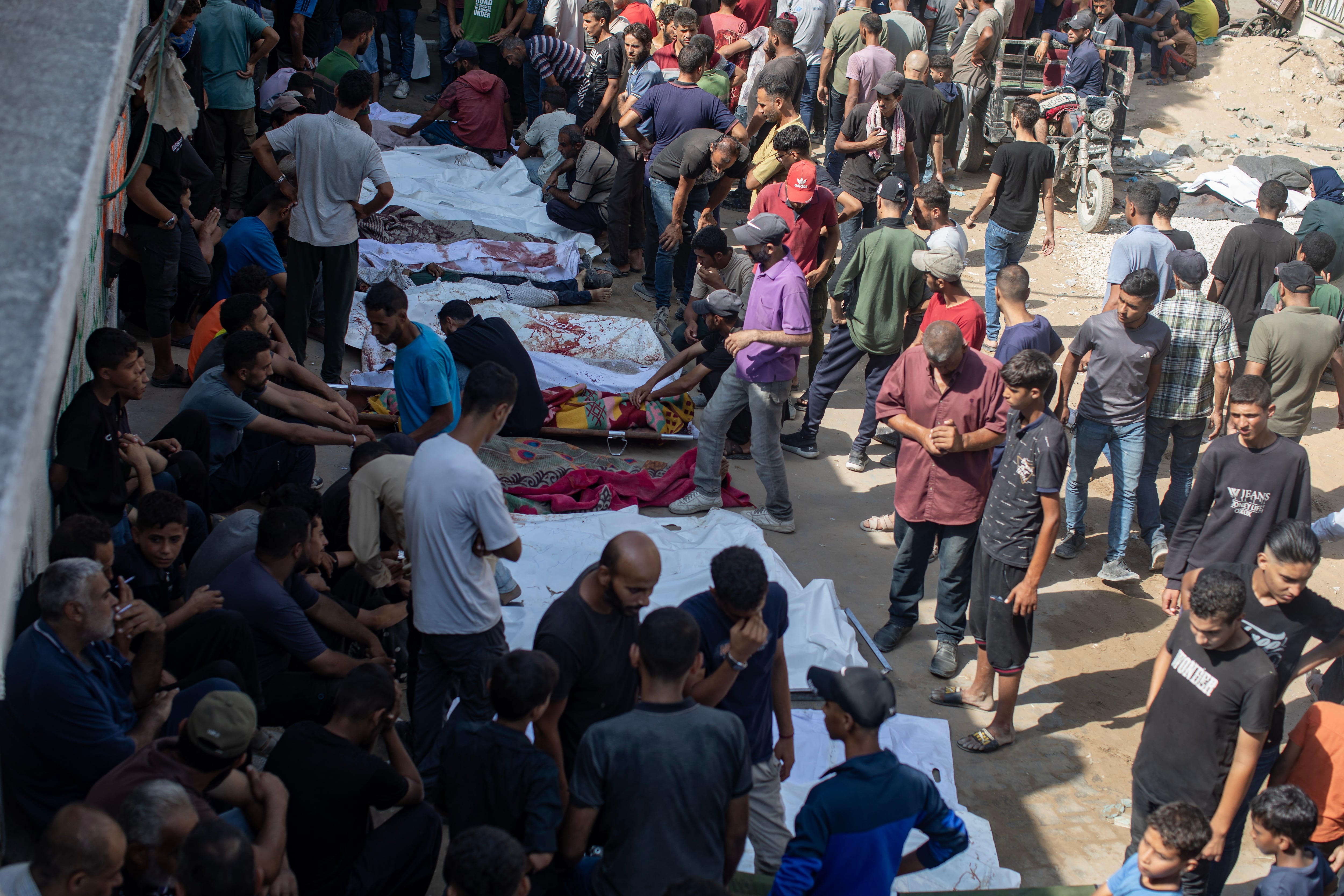 Una multitud de palestinos se concentra en el lugar en el que reposan los cadáveres de las víctimas de un nuevo ataque israelí sobre Gaza.