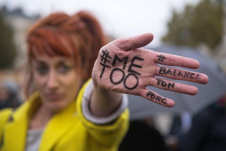 Una mujer enseña su mano escrita con el mensaje &quot;A mi también&quot; durante una manifestación contra el acoso sexual en París