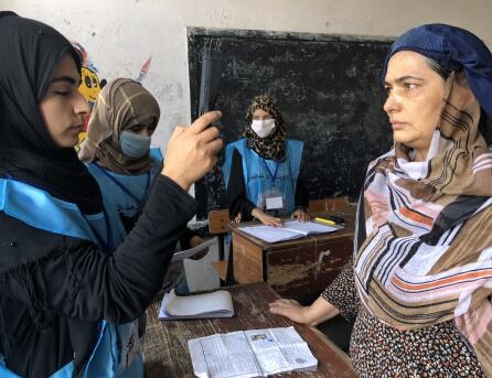 Una mujer es controlada con un aparato biométrico.