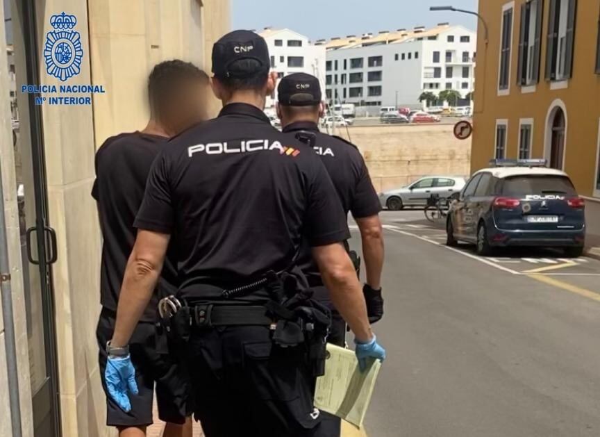 Un dels pressumptes autors del robatori del televisor acompanyat per dos dels policies que el custodien.