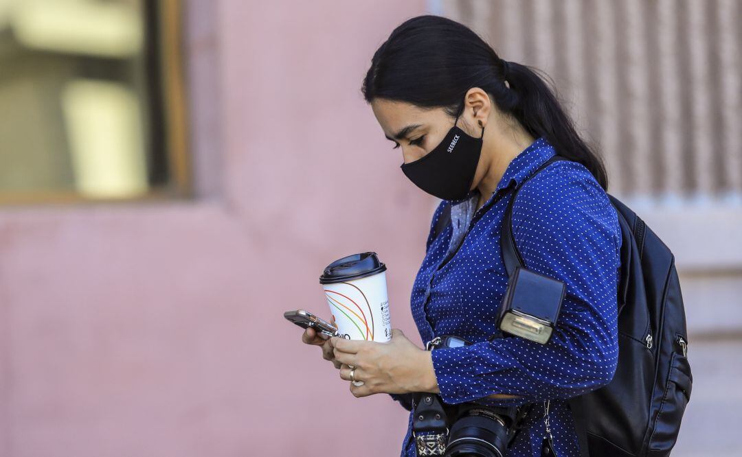 Una mujer utiliza su teléfono móvil.