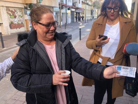 Una de las agraciadas con el quinto premio muestra su décimo