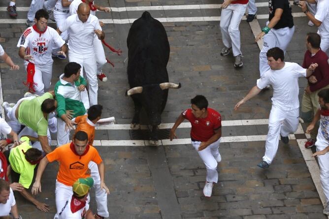 Los mozos corren delante de uno de los toros de la ganadería salmantina de Valdefresno que han protagonizado el tercer encierro de los sanfermines, que ha resultado rápido y muy peligroso