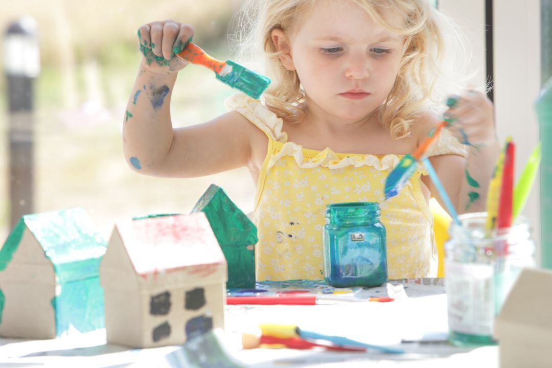 Una niña jugando con pinturas. 