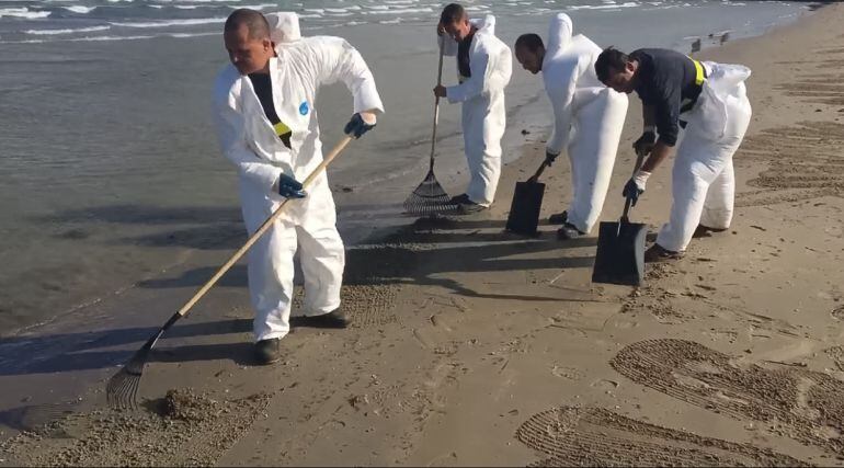 Operarios terminan de limpiar el vertido en la Playa de La Concha, en Algeciras