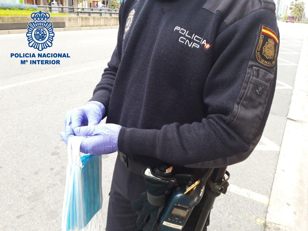 Reparto de mascarillas por parte de un agente.