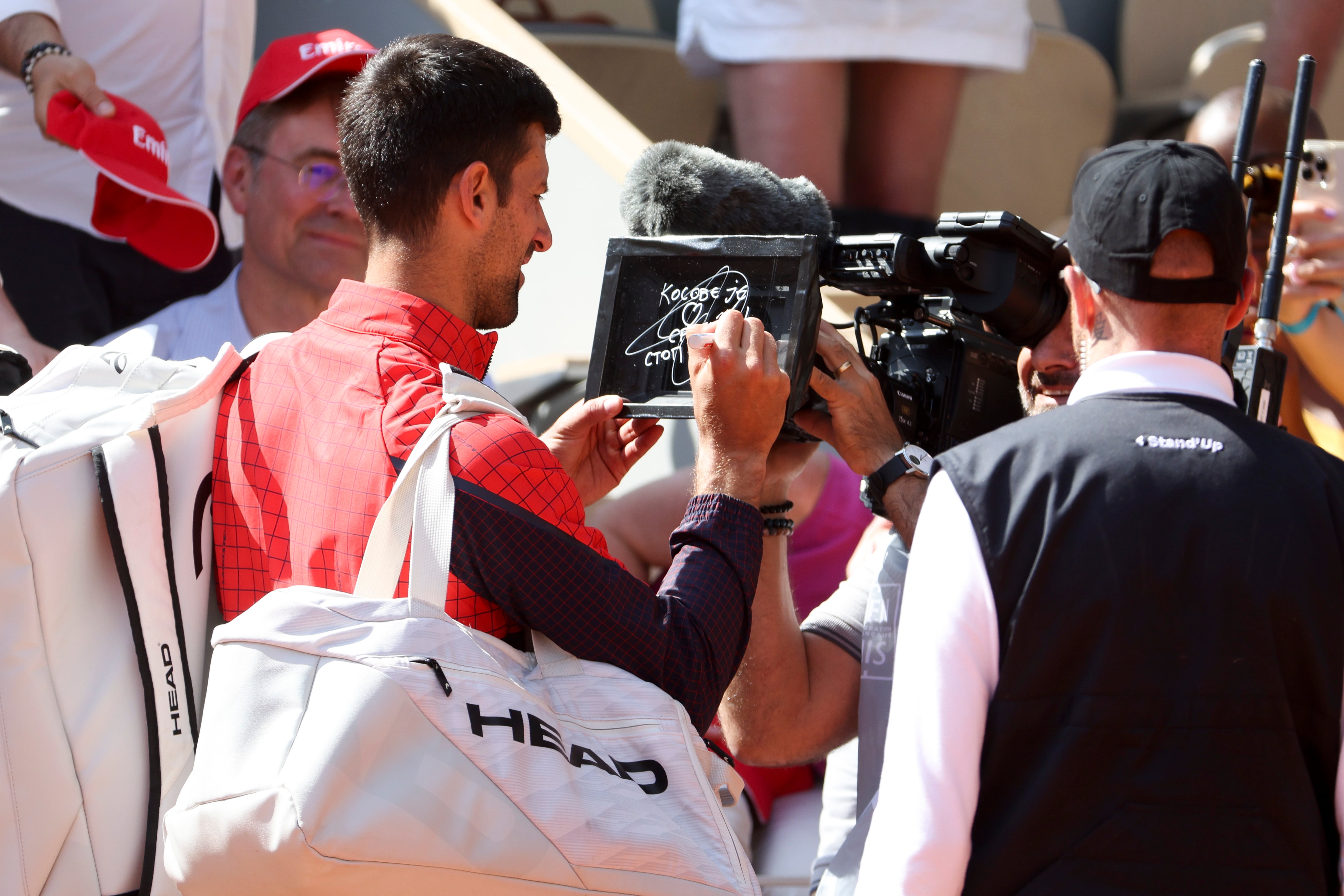 Momento en el que Novak Djokovic escribe su mensaje sobre Kosovo en una cámara