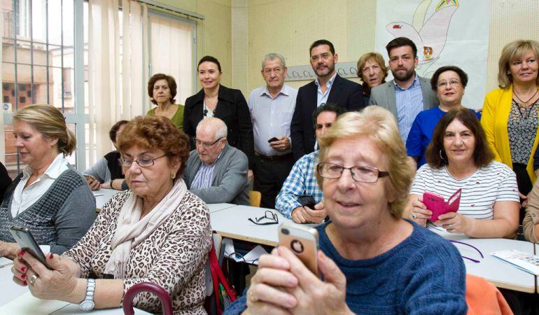 Varios mayores aprendiendo a manejas sus teléfonos inteligentes