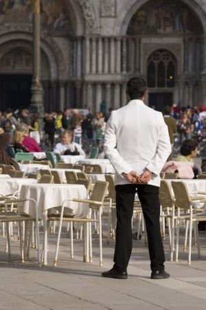 Un camarero, atento a los clientes de la terraza.