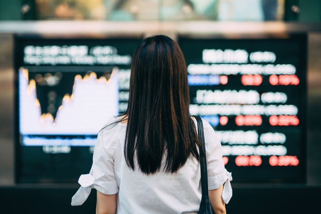 Businesswoman looking at stock exchange market display