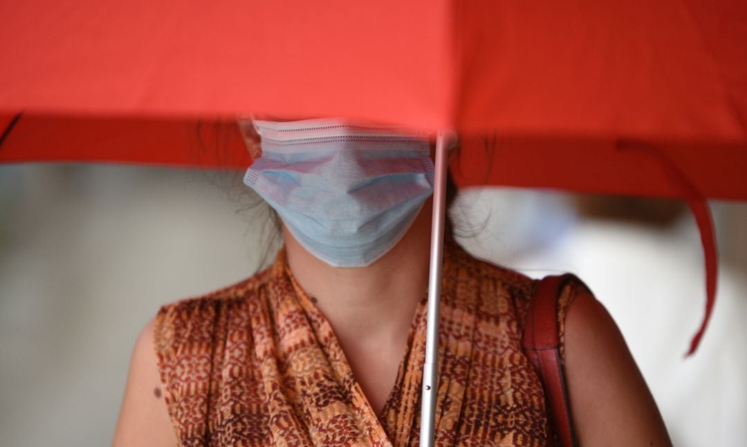 Si llevas mascarilla en un día lluvioso, protégete con un paraguas.