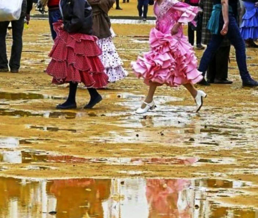 Jóvenes vestidas de gitana sortean charcos en el albero del Real