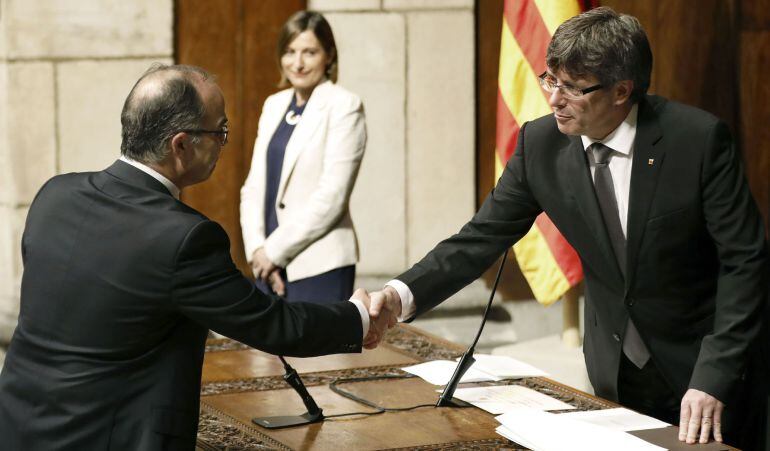 El nuevo conseller de Presidencia, Jordi Turull, saluda al presidente de la Generalitat, Carles Puigdemont