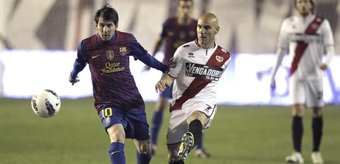 El centrocampista del Rayo Vallecano José María Movilla pugna por el balón con el delantero argentino del FC Barcelona Lionel Messi