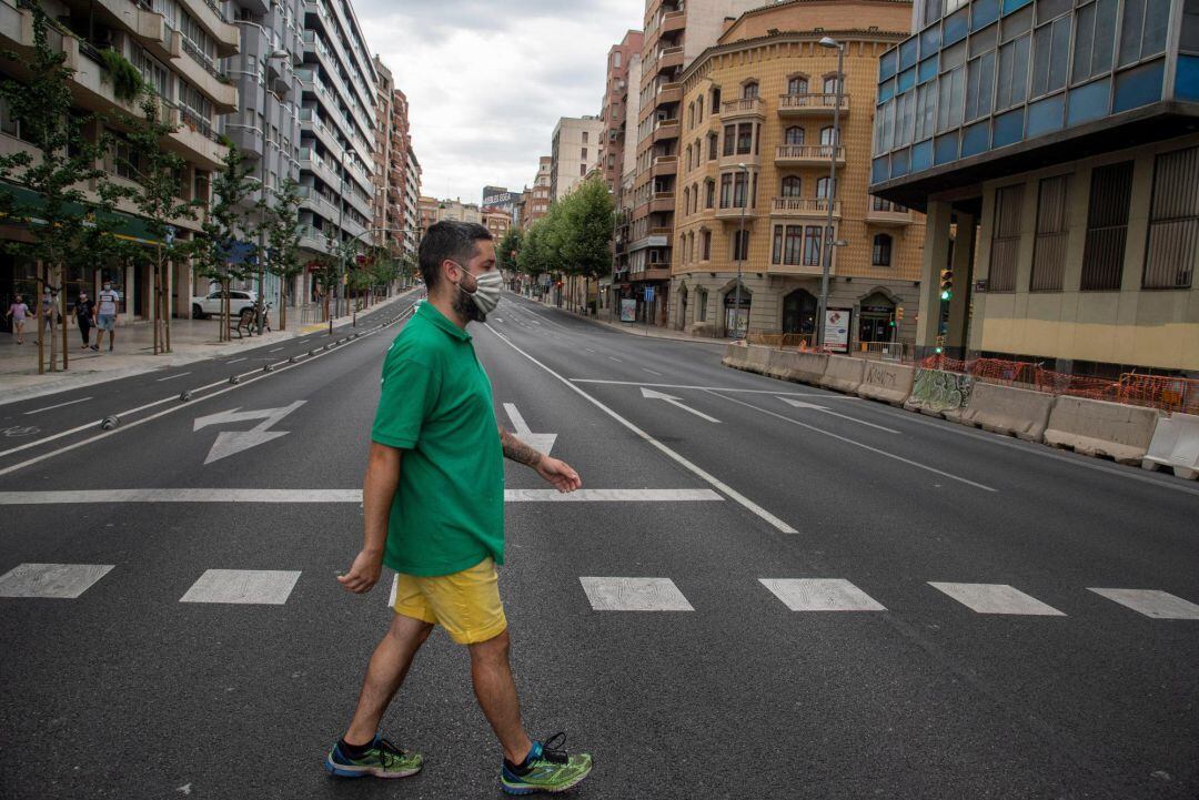 Un vecino cruza la calle en una avenida de Catalunya prácticamente vacía, en una jornada en la que la Generalitat aplicará a partir de esta medianoche un confinamiento domiciliario parcial a los habitantes de Lleida y de otros siete municipios de la comarca del Segrià.