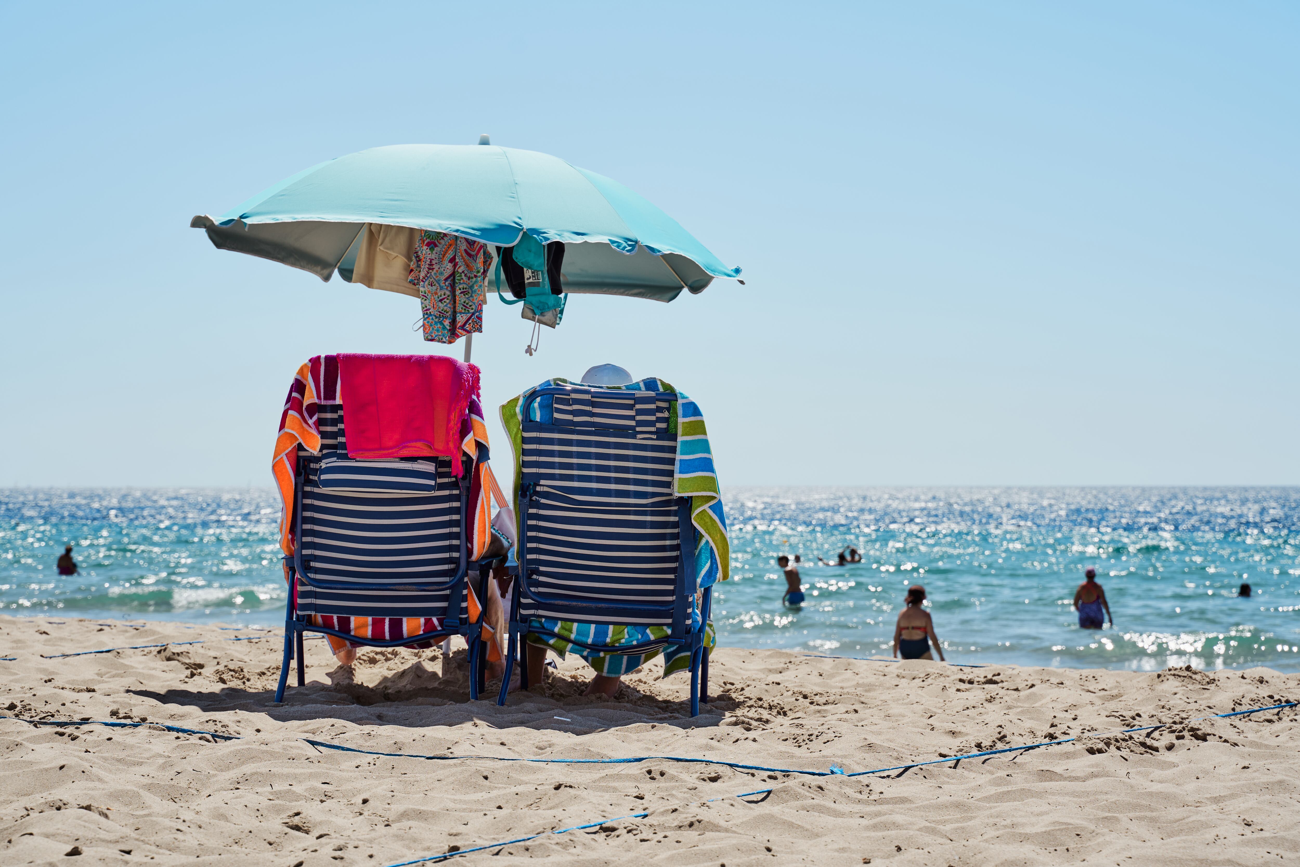 Turistas del IMSERSO toman el sol en la playa de Benidorm