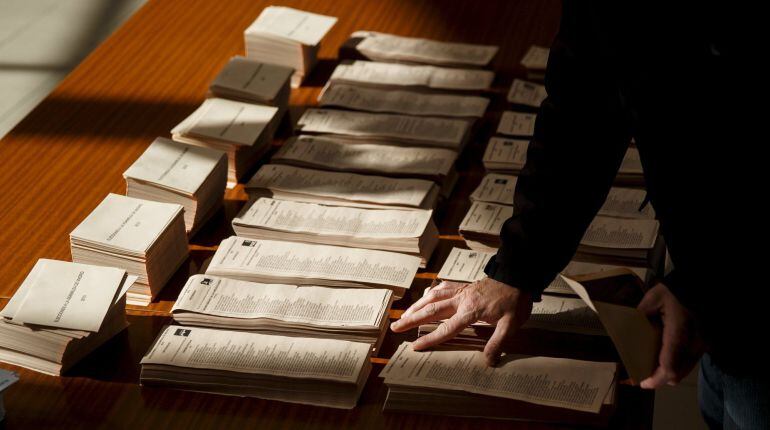 A man looks at ballots at a polling station during regional and municipal elections in Madrid, Spain, May 24, 2015. Spaniards are expected to sweep aside 40 years of predictable politics when they vote in regional elections on Sunday and usher in an unsta