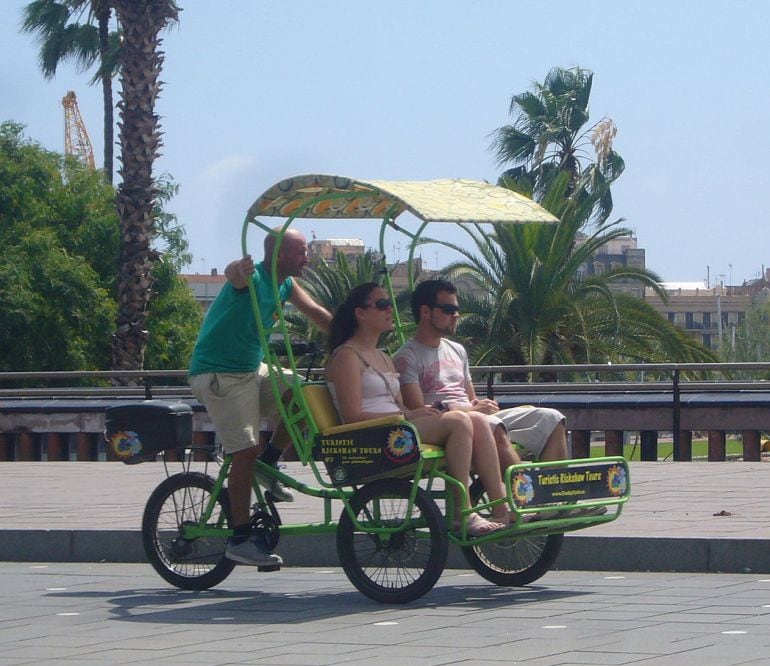 Turistas paseando en un triciclo turístico 