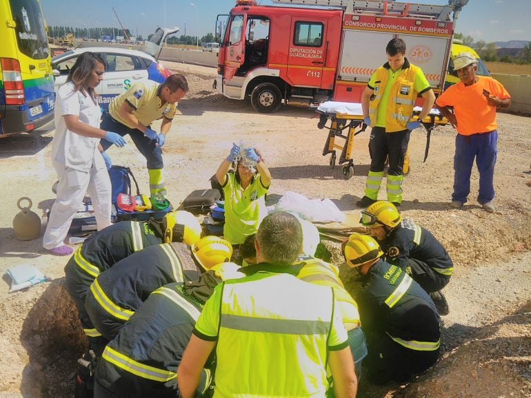 Bomberos y efectivos sanitarios atienden al trabajadore herido ayer en Marchamalo.