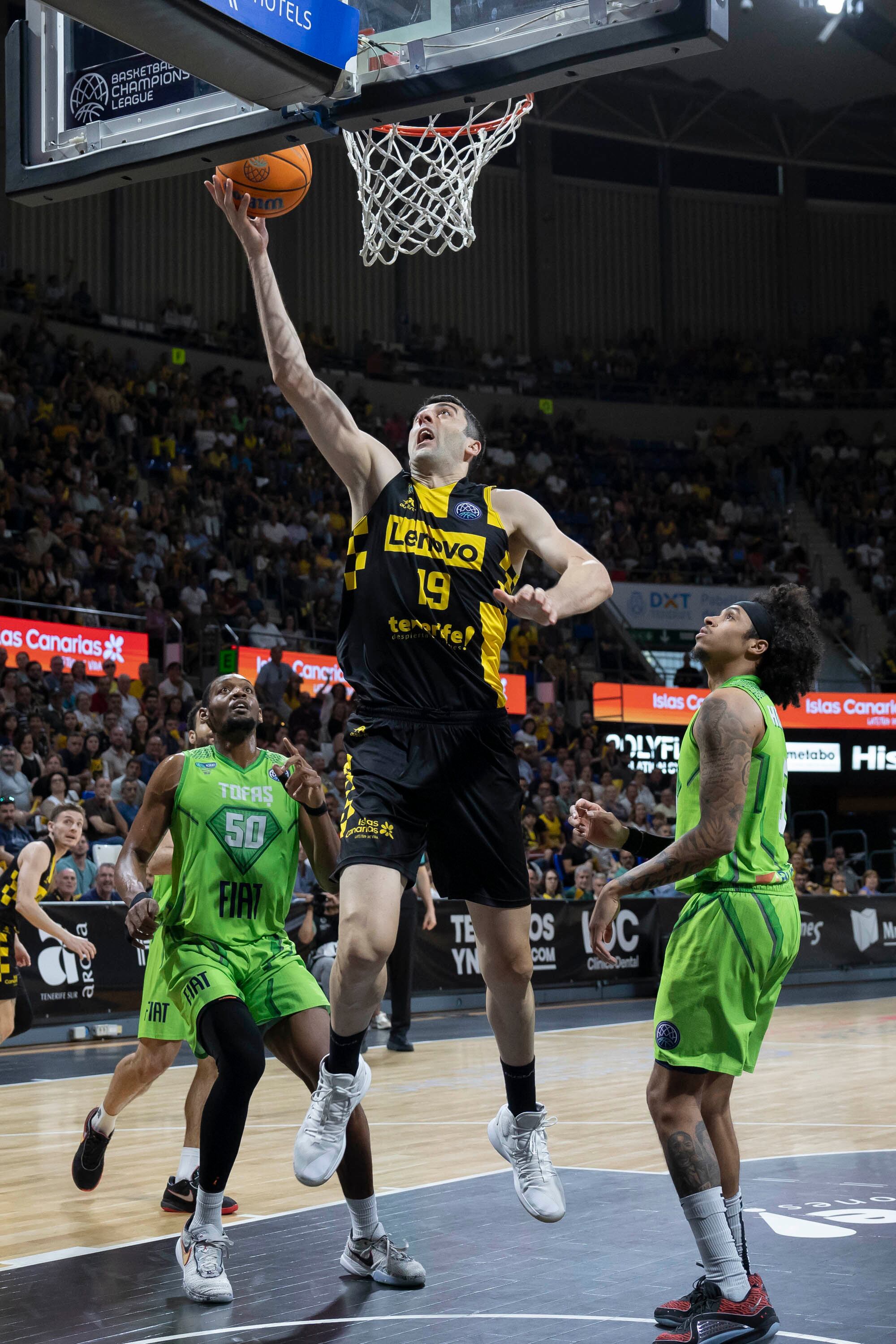 LA LAGUNA (TENERIFE), 17/04/2024.- El pívot del Lenovo Tenerife Giorgi Shermadini (c) entra a canasta, durante el tercer partido de los playoffs de cuartos de final de la Liga de Campeones de baloncesto ante el Tofas Bursa disputado este miércoles en el pabellón Santiago Martín de La Laguna, en Tenerife. EFE/Miguel Barreto