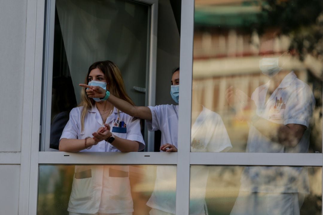 Sanitarios aplauden desde una ventana del Hospital Fundación Jiménez Díaz en Madrid