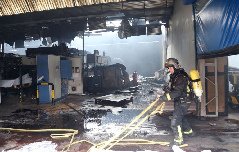 Los bomberos trabajan en la extinción del incendio en Macrolibros