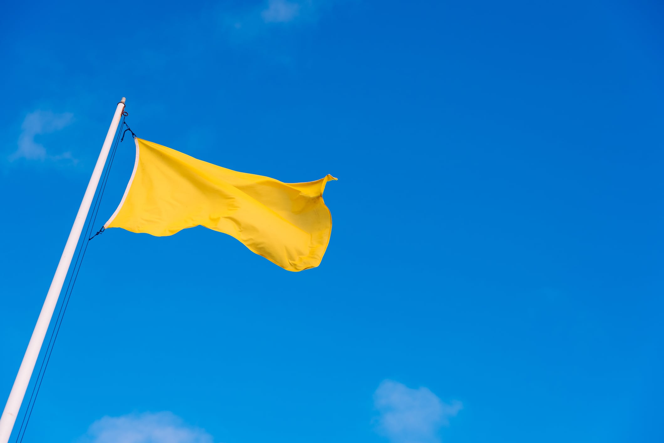 Una bandera amarilla ondea en la playa.