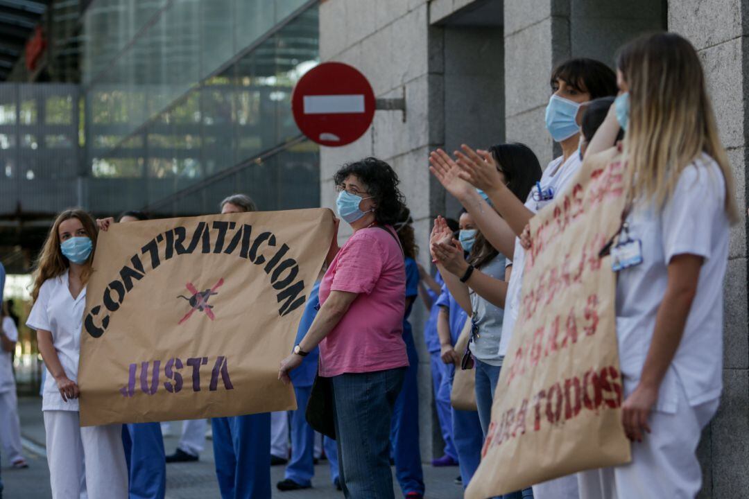 Personal sanitario sostienen carteles en los que se lee 'Contratación justa'.