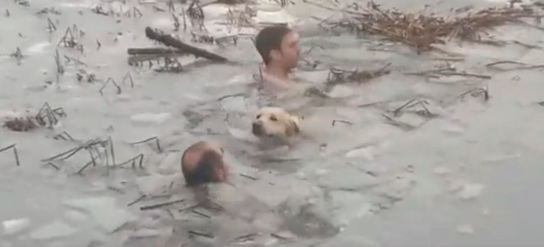 Dos agentes de la Guardia Civil rescatando al perro 