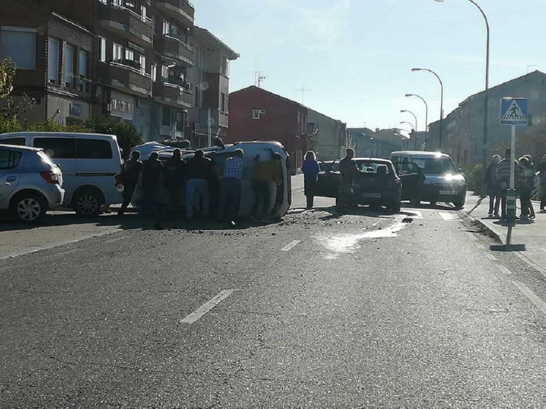 Varios vecinos levantan el vehículo volcado el pasado sábado