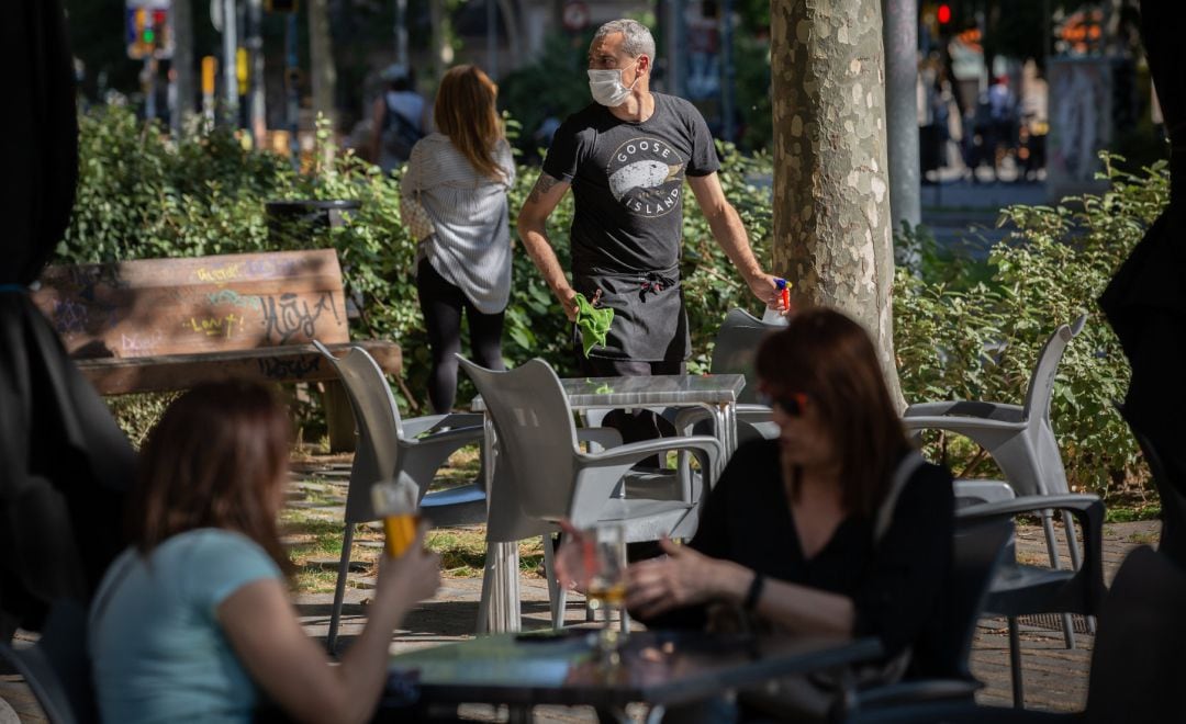 Varias personas disfrutan en la terraza de un bar en Barcelona