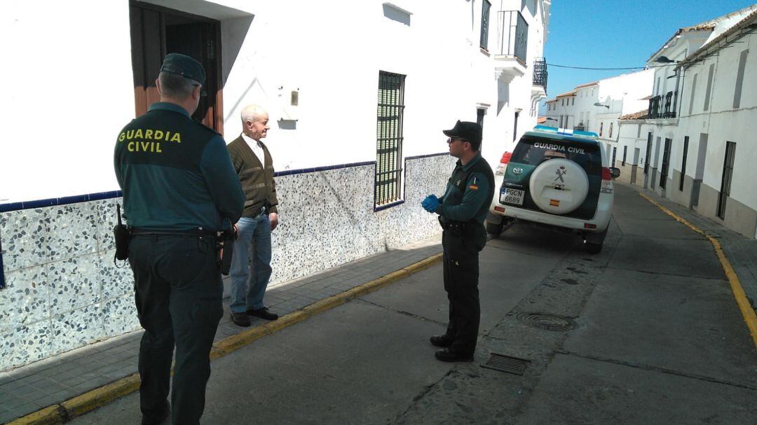Agentes de la Guardia Civil informan a un vecino de Aracena sobre el Plan Mayor Seguridad.
