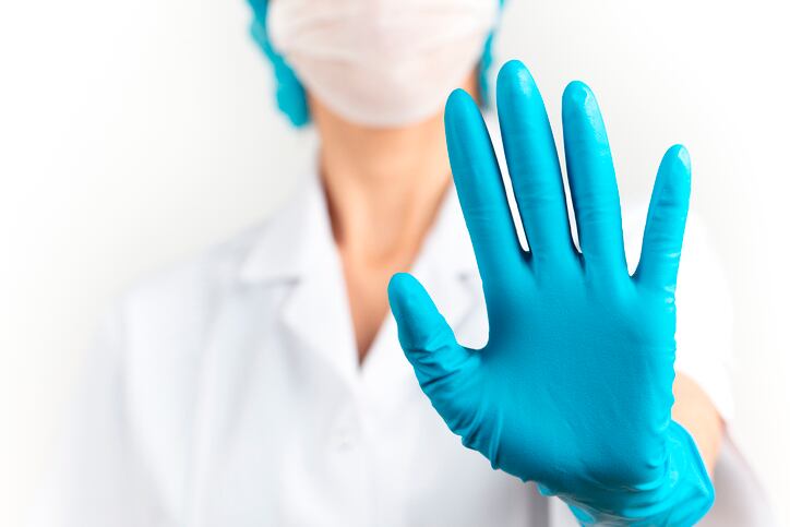 young woman doctor is making stop sign. White background