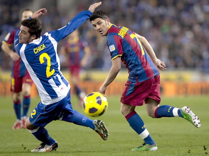 El delantero del F. C. Barcelona David Villa pelea un balón con el defensa del RCD Espanyol Javier Chica durante el encuentro correspondiente a la decimosexta jornada de Primera División