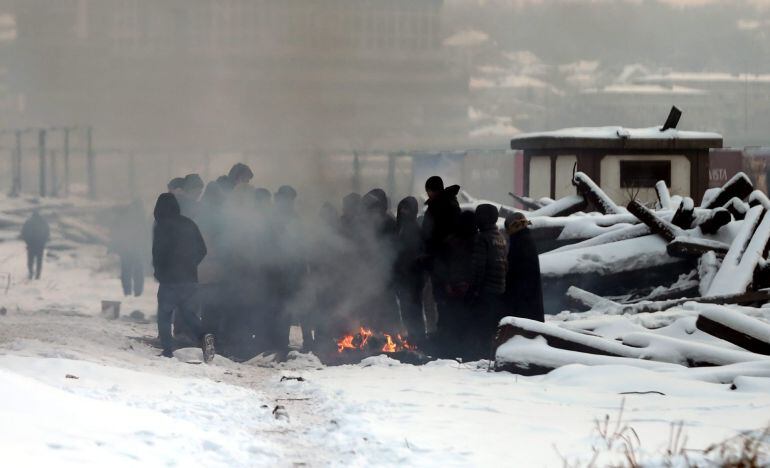 Varios refugiados se protegen del frío con una hoguera en un almacén aduanero abandonado en Belgrado, Serbia.