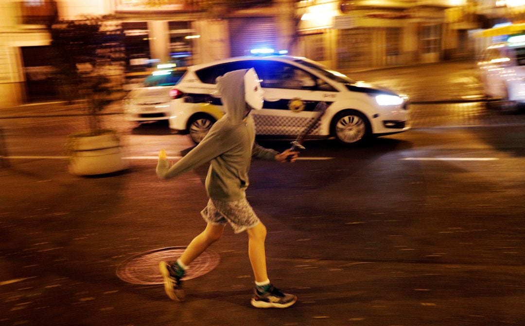 Un niño disfrazado corre por el centro de la ciudad durante esta noche en la que se celebra un Halloween &quot;descafeinado&quot;, con toque de queda y mayor presencia policial.