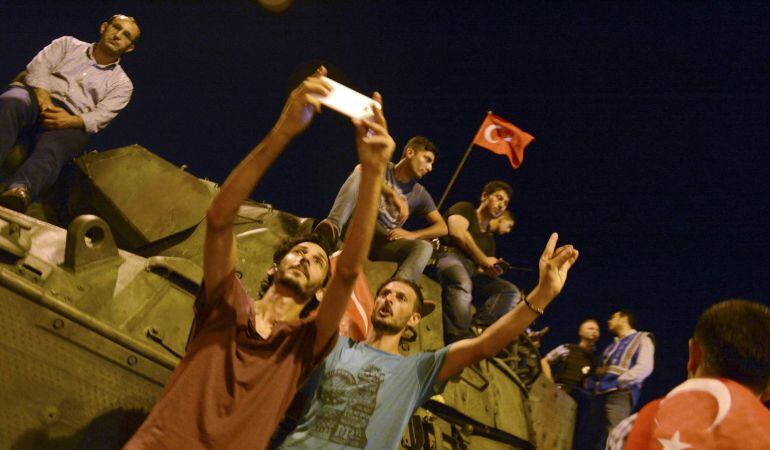 Partidarios de Tayyip Erdogan sacan fotos frente a un tanque frente al aeropuerto Ataturk de Estambul.