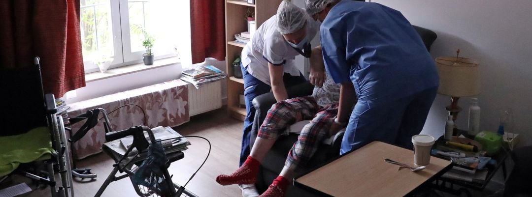 Personal de una residencia de ancianos con una usuaria