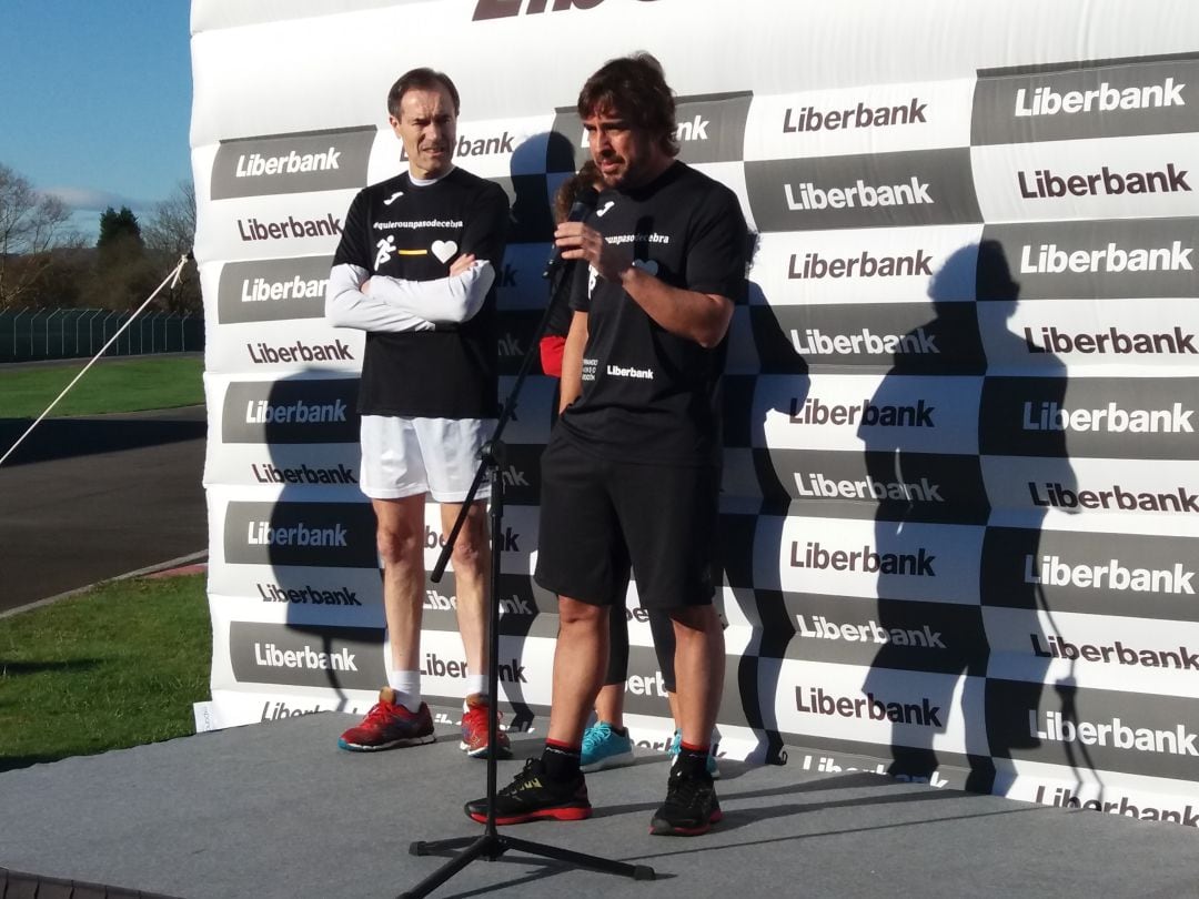 Fernando Alonso se dirige a los asistentes y participantes en la carrera bajo la atenta mirada del consejero delegado de Liberbank, Manuel Menéndez