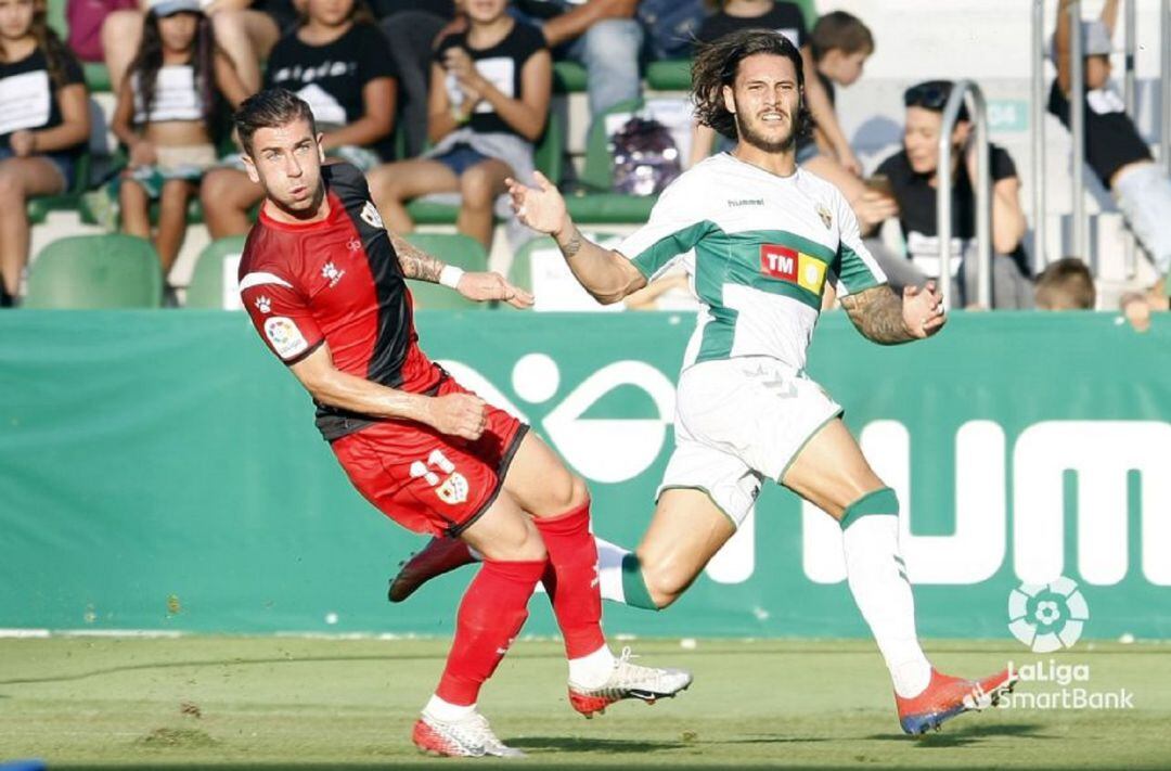 El jugador del Elche Juan Cruz y el rayista Embarba en un momento del partido