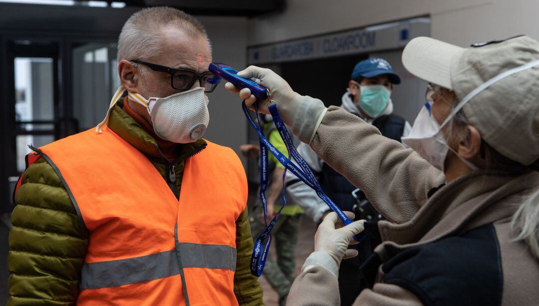 Una enfermera toma la temperatura a una persona para comprobar si tiene fiebre.