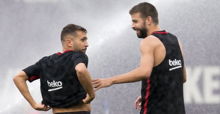 Piqué y Jordi Alba bromean durante un entrenamiento del Barcelona