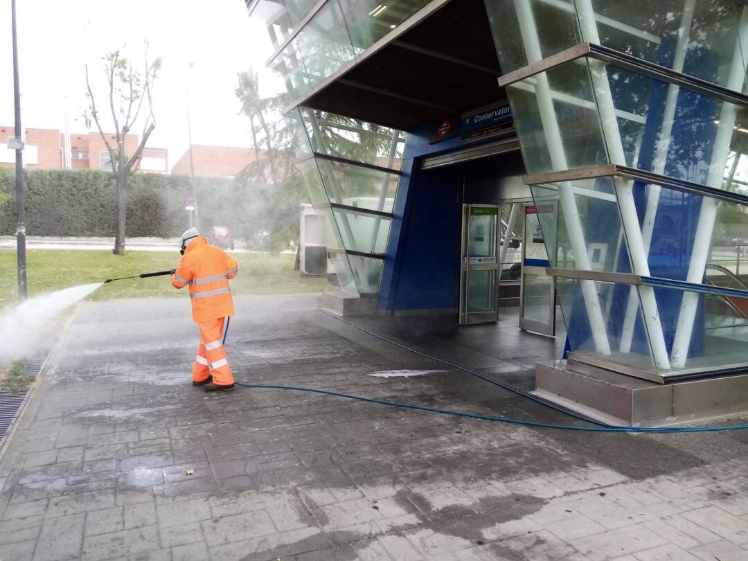 Un operario de limpieza desinfecta la entrada de la estación de Metrosur de Conservatorio.