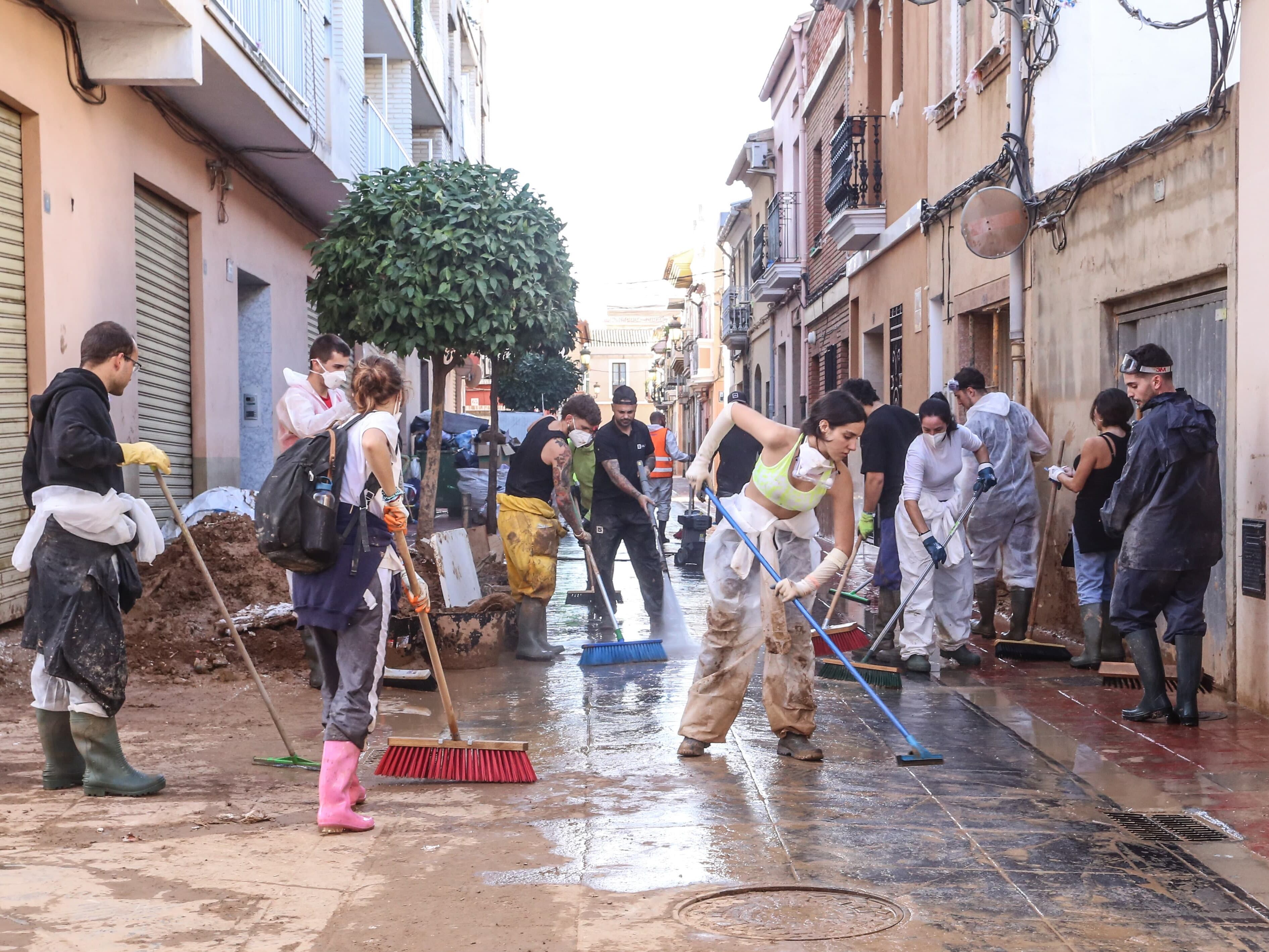 Varios voluntarios y voluntarias eldenses  realizan labores de limpieza en las calles de Sedaví.