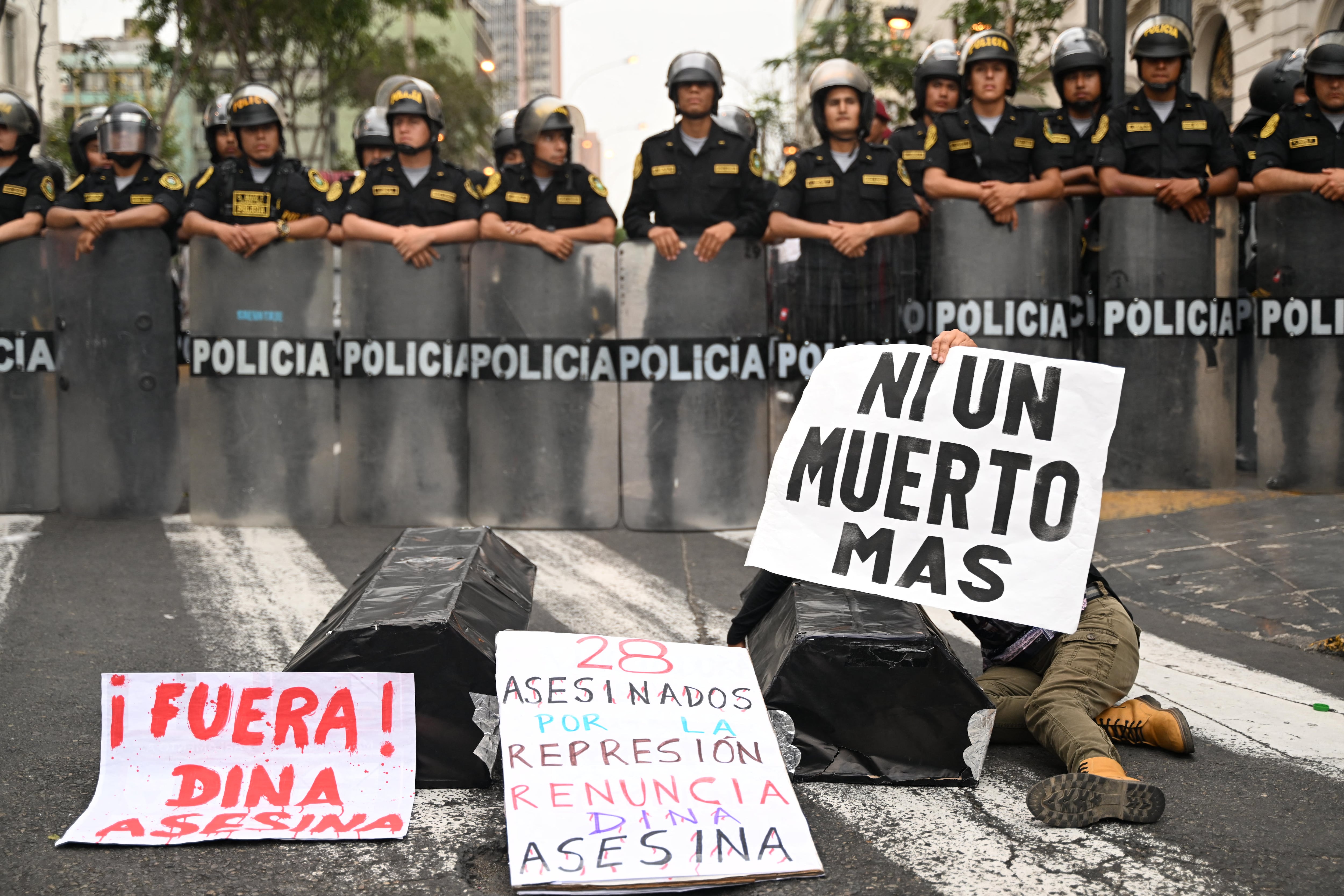 Un manifestante sostiene una pancarta que denuncia la muerte de 28 ciudadanos de Perú durante las protestas