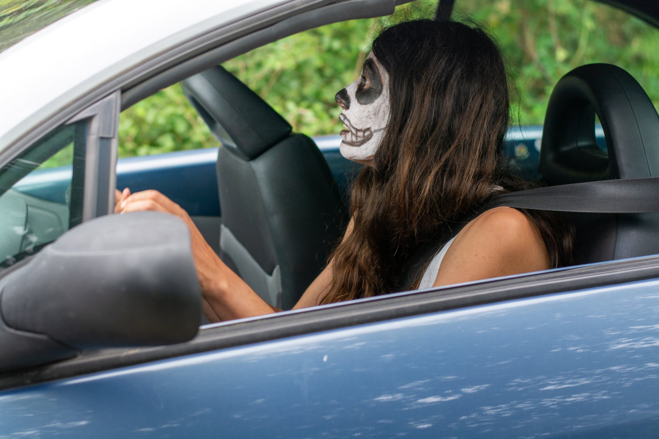 Una conductora sostiene el volante con la cara pintada.